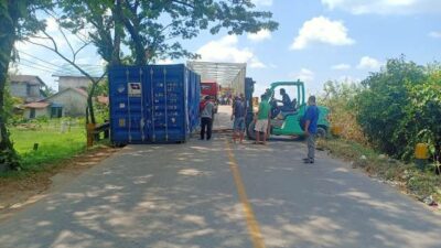 Petugas sedang mengevakuasi kontainer yang terlepas dari trailer di pintu masuk Jembatan Ambawang Jalan Trans Kalimantan, Kamis (18/5)