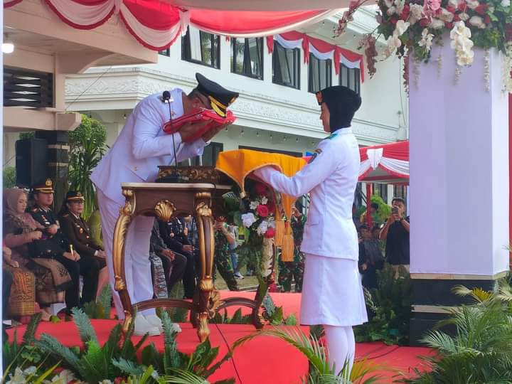 Pj Wali kota Singkawang Sumastro mencium bendera merah putih sebelum diserahkan ke petugas Paskibraka untuk dikibarkan saat upacara memperingati HUT ke-78 Kemerdekaan RI, Kamis (17/8).