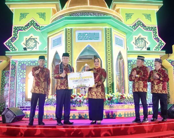 Sekda Kalbar Harrison menyerahkan simbolis juara kepada Bupati Mempawah Erlina dimana Kabupaten Mempawah sebagai juara umum MTQ XXXI Kalbar yang dihelat di Sanggau dengan meraih point 80, Kamis (31/8) malam. Foto: pek