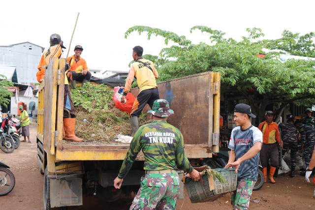 Personel gabungan dari unsur TNI, Polri dan Pemda Ketapang gotong royong bersihkan pasar untuk mencegah terjadinya banjir dan DBD, Kamis (7/12). Foto: naufal