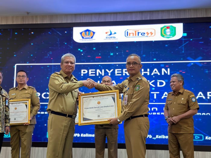 Pj Gubernur Kalbar, Harisson menyerahkan penghargaan kepada Pj Wali Kota Singkawang Sumastro saat Penyerahan DIPA APBN dan Transfer ke Daerah dan Dana Desa di Pontianak, Selasa (5/12). Foto: uck