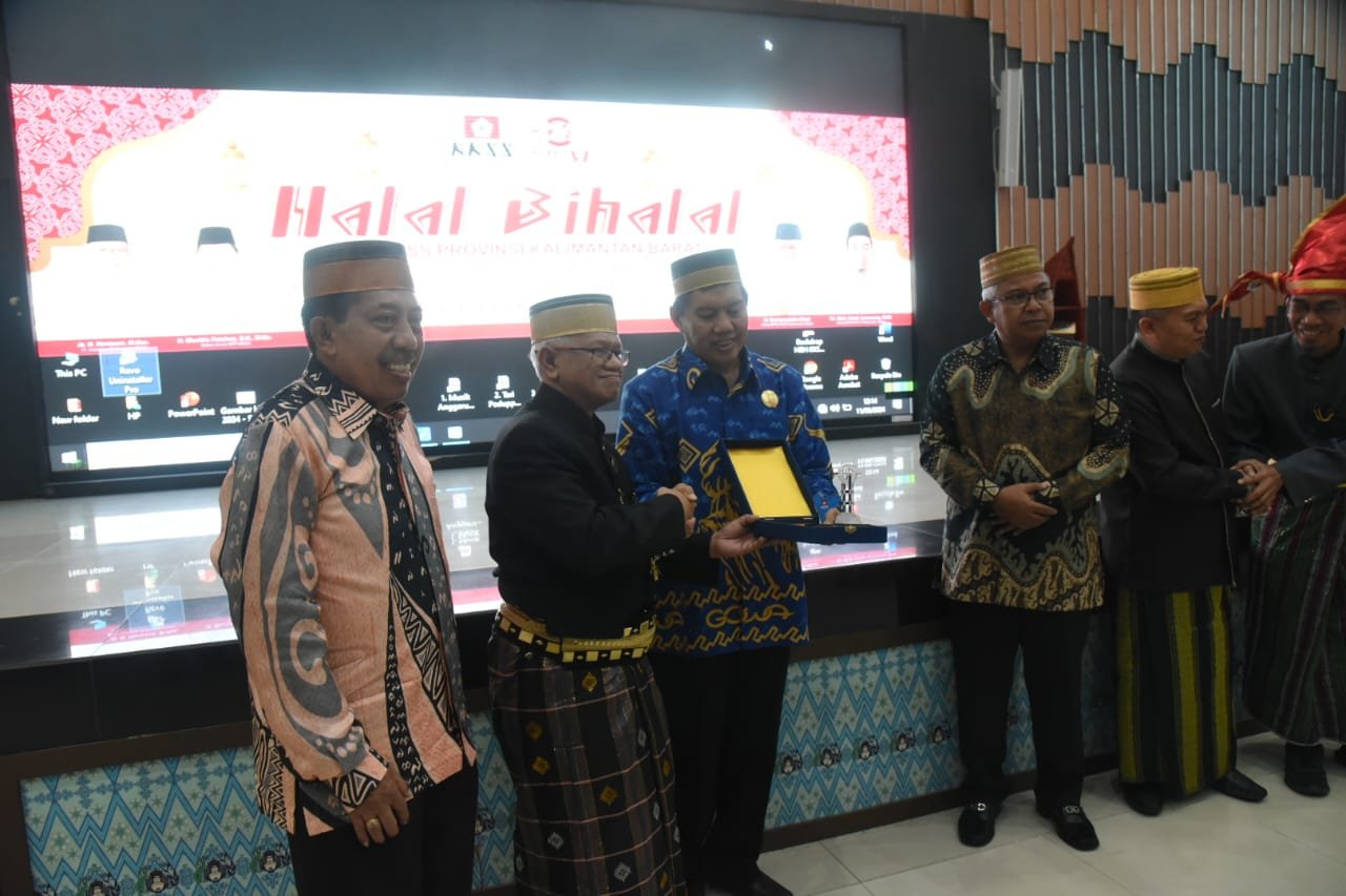 Ketua BPD KKSS Kalbar Burhanudin Ahad saat memberikan cinderamata kepada Ketua BPP KKSS Muhlis Patahna saat halal bihalal dan pembukaan Muswil VI KKSS, Sabtu (11/5). Foto: eji