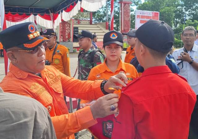 Pj Bupati Sanggau melakukan penyematan tanda kesiapsiagaan petugas menghadapi bencana, Rabu (12/6). Foto: pek