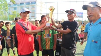 Kepala Dinas Pendidikan dan Kebudayaan Kubu Raya M Ayub menyerahkan piala bergilir kepada manajer tim Rasau Jaya yang berhasil menjadi juara Pra GSI O2SN tingkat SD Kabupaten Kubu Raya