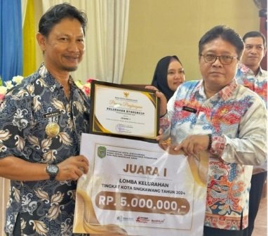 Kepala Dinas Sosial, Pemberdayaan Perempuan dan Perlindungan Anak (Dinsos PPPA) Kota Singkawang Sutiyarto saat menyerahkan hadiah kepada Lurah Nyarumkop yang berhasil menyabet juara 1 lomba kelurahan di Singkawang. Foto: uck
