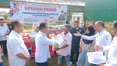 Pj Bupati Sanggau Suherman menyerahkan simbolis sembako yang dibeli masyarakat saat Operasi Pasar Murah di Sanggau, Rabu (31/7). Ada tiga jenis sembako yang dijual hanya dihargai Rp70 ribu per paket. Ketiga jenis sembako itu yakni beras kualitas premium 5 Kg, minyak goreng 1 liter dan gula 1 Kg. Foto: pek