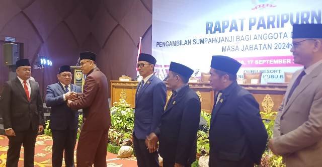 Ketua DPRD Kubu Raya 2019 - 2024, Agus Sudarmansyah menyerahkan palu pimpinan sidang dan memori kepada Pimpinan Sementara DPRD Kubu Raya saat pelantikan anggota DPRD Kubu Raya masa bakti 2024 - 2029, Selasa (17/9). Foto: dian