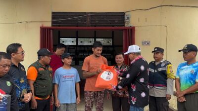 Penjabat Sekda Sanggau Aswin Khatib didampingi Kadinsos P3AKB Sanggau Aloysius Yanto menyerahkan simbolis bantuan kepada warga korban banji bandang di Desa Kedakas Kecamatan Tayan Hulu, Jumat (27/9). Foto: pek