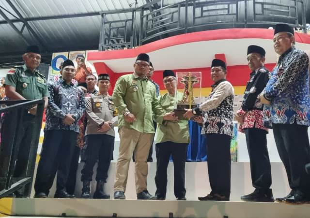 Pj Bupati Sanggau, Suherman menyerahkan piala bergilir menjadi piala tetap MTQ kepada Ketua LPTQ Kapuas, Ambari didampingi Camat Kapuas, Laurianus Yoka. Di MTQ XXXII tingkat Kabupaten Sanggau tahun 2024 Kecamatan Kapuas berhasil meraih juara umum yang diumumkan pada Sabtu (28/9) malam sekaligus penutupan. Foto: pek