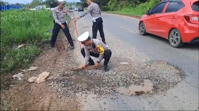 Polisi Tambal Jalan Nasional Makan Korban