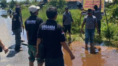 Para pengusaha transportasi angkutan darat yang tergabung dalam Organda Kalbar melakukan aksi sosial dengan melakukan penimbunan jalan berlubang dan memasang banner peringatan di Jalan Trans Kalimantan yang terendam banjir rob, Minggu (9/3/2025). Foto: tmB/berkatnewstv